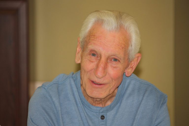 radio: an older gentleman wearing a light blue henley