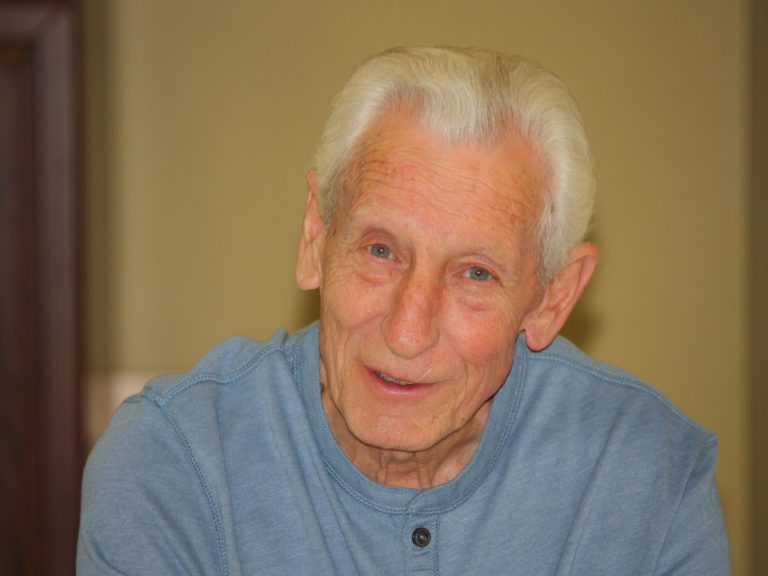 radio: an older gentleman wearing a light blue henley