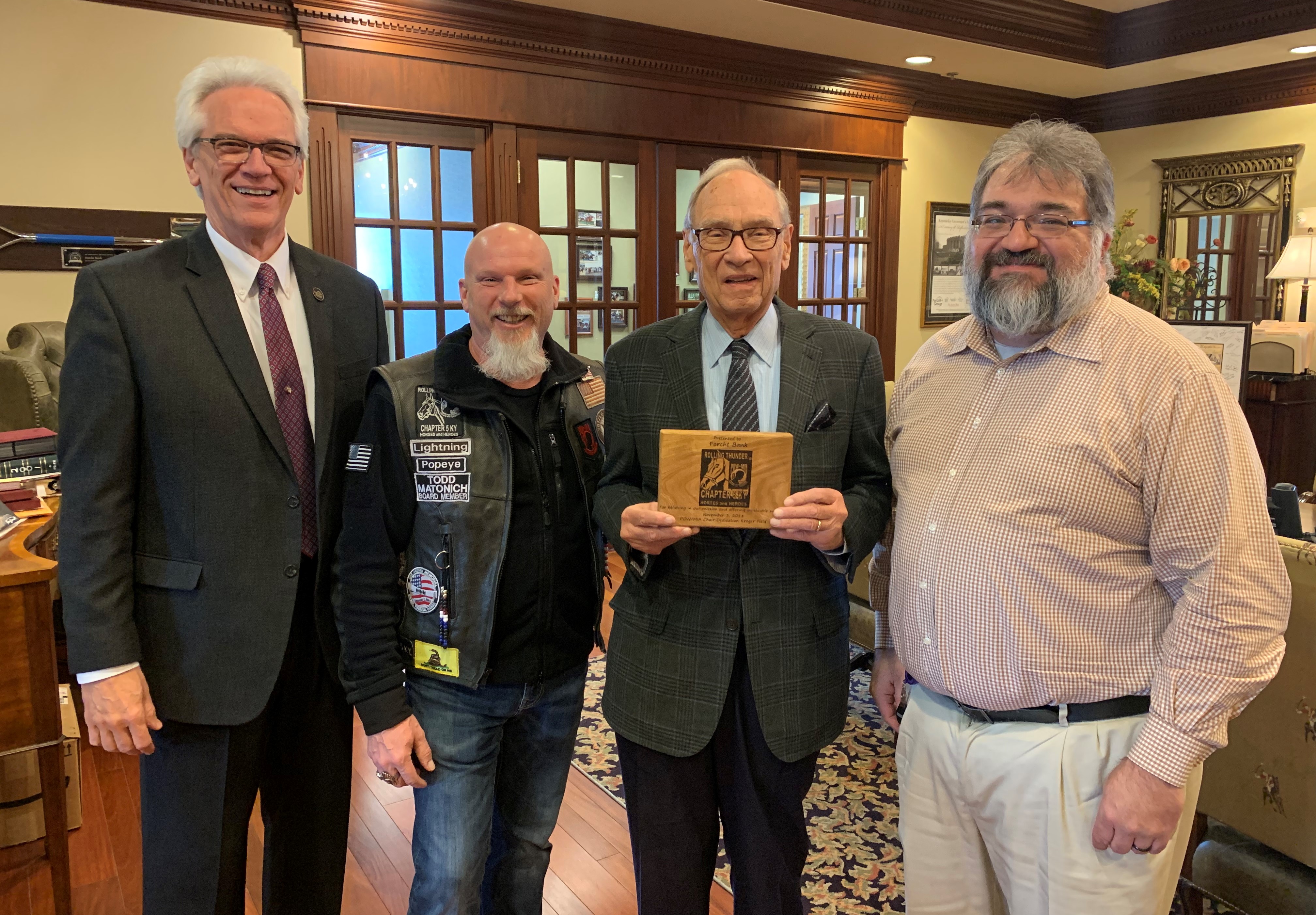 Rolling Thunder: four men smiling at the camera holding a plaque