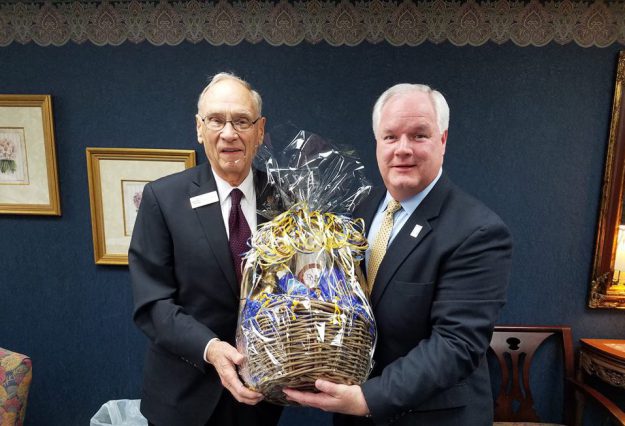 mike tarter Forcht Broadcasting: two men in suits holding a basket smiling at the camera