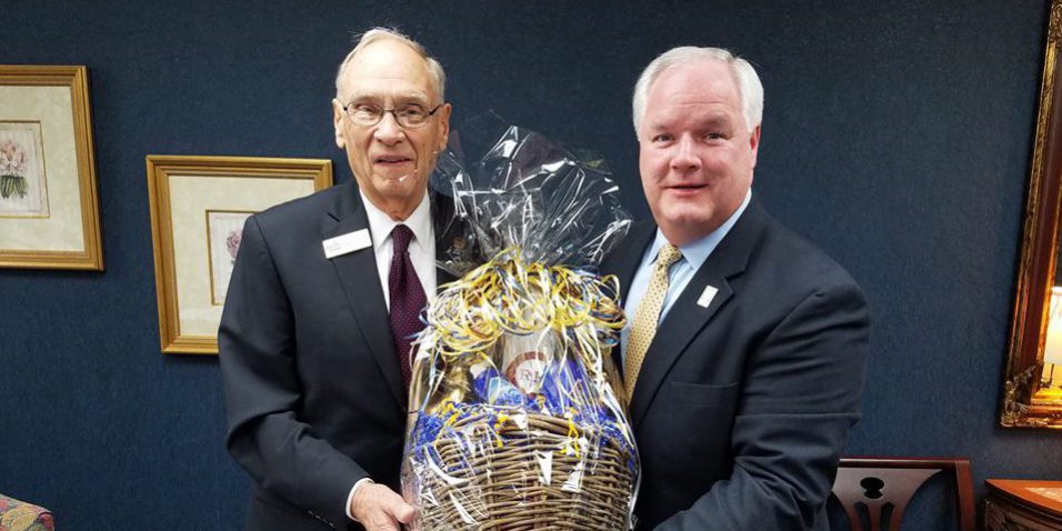 mike tarter Forcht Broadcasting: two men in suits holding a basket smiling at the camera
