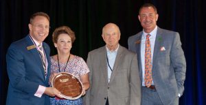 Small Business: three men and a woman smiling at the camera holding a trophy