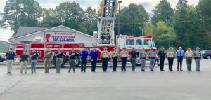 Forcht Bank: uniformed officers standing in front of a fire truck saluting